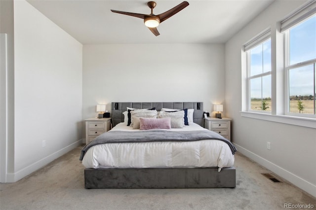 bedroom featuring light colored carpet, ceiling fan, baseboards, and visible vents