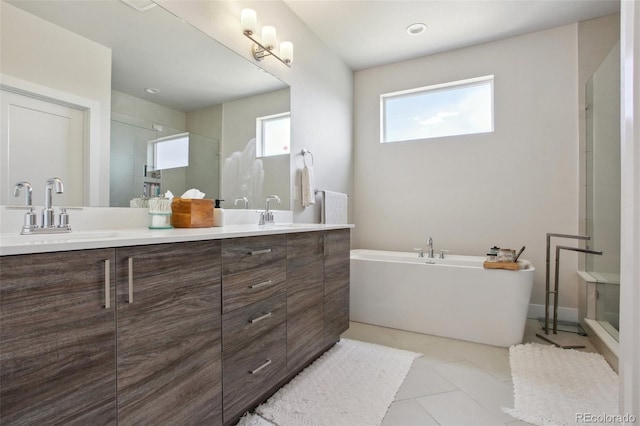 full bathroom with a freestanding bath, a sink, double vanity, and a stall shower