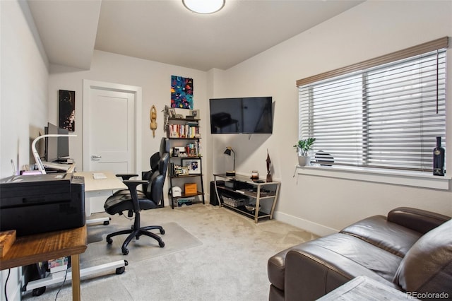 home office with baseboards and light colored carpet