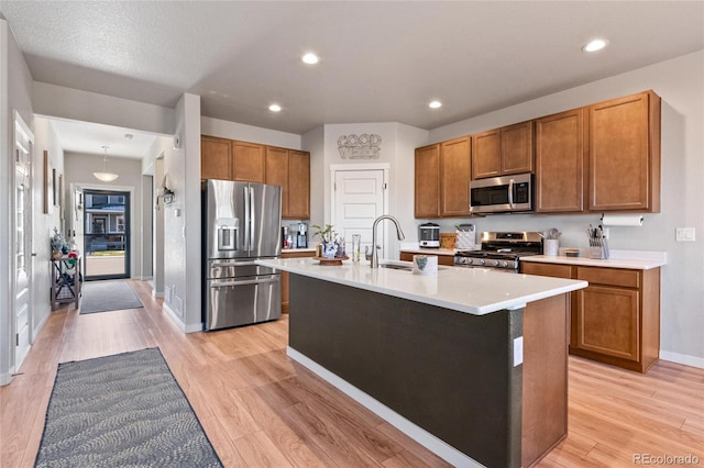 244 Chipeta Way, Lochbuie, CO 80603 - kitchen with stainless steel appliances, a sink, light countertops, brown cabinetry, and recessed lighting