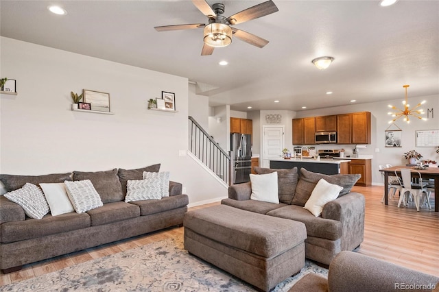 244 Chipeta Way, Lochbuie, CO 80603 - living room with stairs, light wood-style flooring, a chandelier, recessed lighting, and a ceiling fan