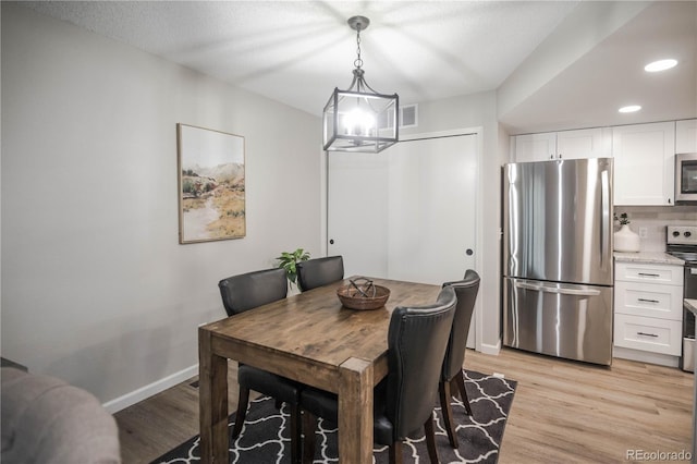 dining room with a notable chandelier and light wood-type flooring