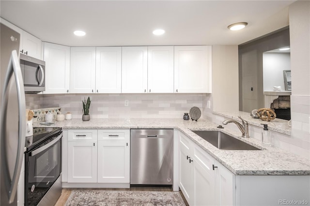 kitchen featuring white cabinets, backsplash, stainless steel appliances, and sink