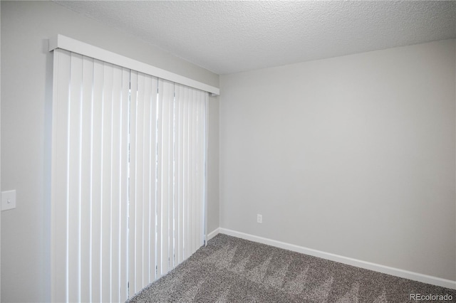 unfurnished room with carpet floors and a textured ceiling