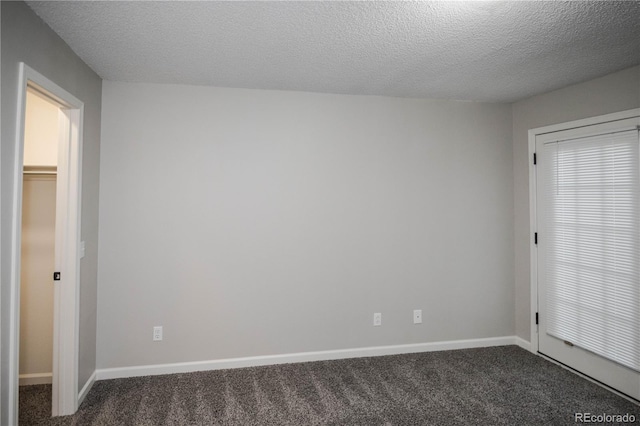 carpeted spare room with a textured ceiling