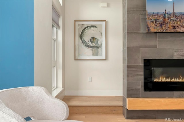 interior details with hardwood / wood-style flooring and a tiled fireplace