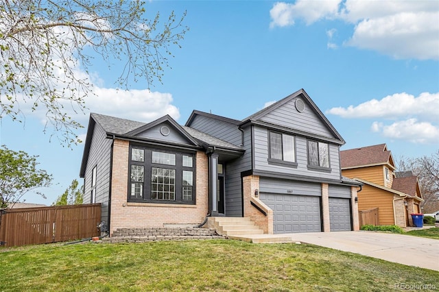 tri-level home with a front lawn, fence, brick siding, concrete driveway, and an attached garage