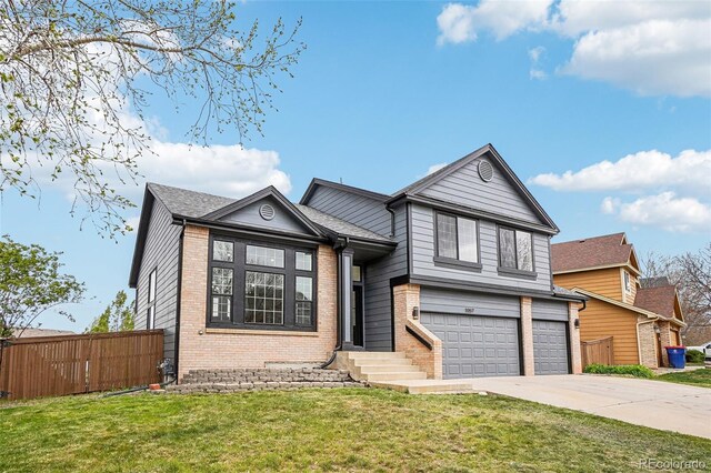 1057 English Sparrow Trl, Highlands Ranch, CO 80129 - tri-level home with a front lawn, fence, brick siding, concrete driveway, and an attached garage