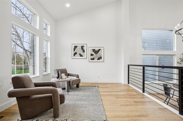 sitting room featuring baseboards, recessed lighting, high vaulted ceiling, and wood finished floors