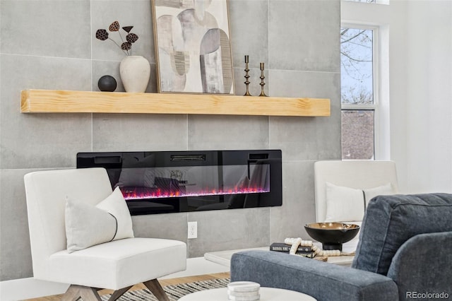 living room with a glass covered fireplace and wood finished floors