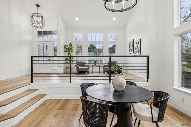 1057 English Sparrow Trl, Highlands Ranch, CO 80129 - dining room with light wood-style floors, a chandelier, recessed lighting, baseboards, and a towering ceiling