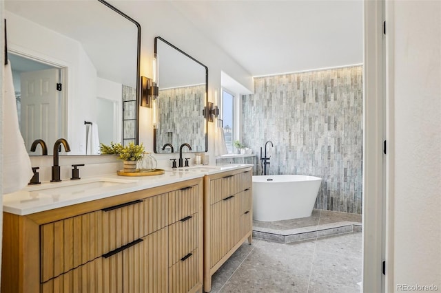bathroom with double vanity, a sink, and a soaking tub