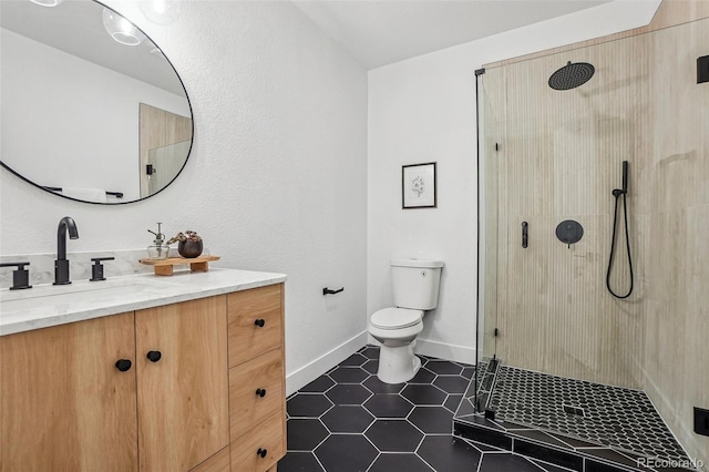 full bathroom featuring a stall shower, vanity, tile patterned floors, baseboards, and toilet