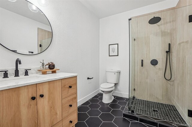 1057 English Sparrow Trl, Highlands Ranch, CO 80129 - full bathroom featuring a stall shower, vanity, tile patterned floors, baseboards, and toilet