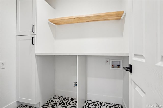 laundry area featuring baseboards, hookup for a washing machine, and cabinet space