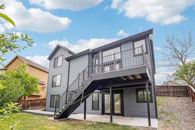 back of house featuring a lawn, a deck, a patio area, stairway, and a fenced backyard