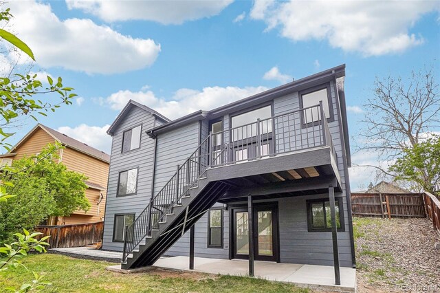 1057 English Sparrow Trl, Highlands Ranch, CO 80129 - back of house featuring a lawn, a deck, a patio area, stairway, and a fenced backyard