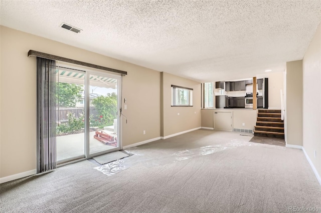 1729 S Ouray Ct, Aurora, CO 80017 - unfurnished living room featuring carpet flooring, a textured ceiling, and stairs