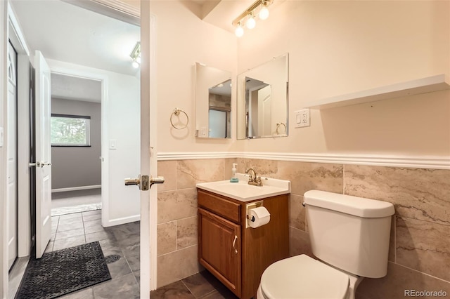 1729 S Ouray Ct, Aurora, CO 80017 - bathroom featuring tile walls, vanity, a wainscoted wall, and tile patterned flooring
