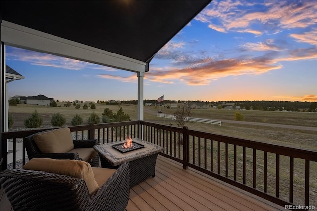 deck at dusk with a rural view and an outdoor fire pit