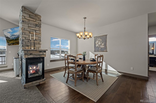 dining space with dark hardwood / wood-style flooring, a fireplace, and a chandelier