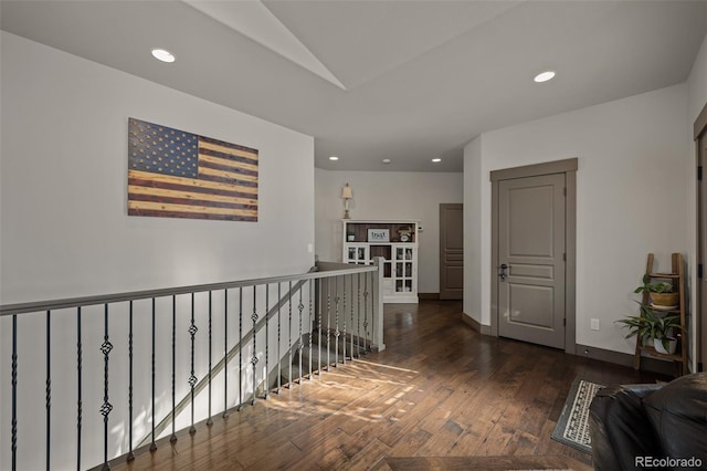 hallway with dark hardwood / wood-style floors and vaulted ceiling