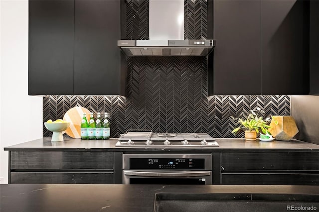 kitchen featuring decorative backsplash, wall chimney range hood, and stainless steel appliances