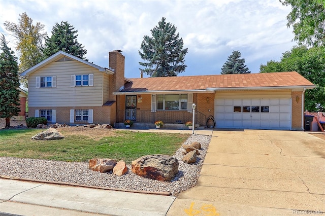 tri-level home featuring a garage and a front lawn