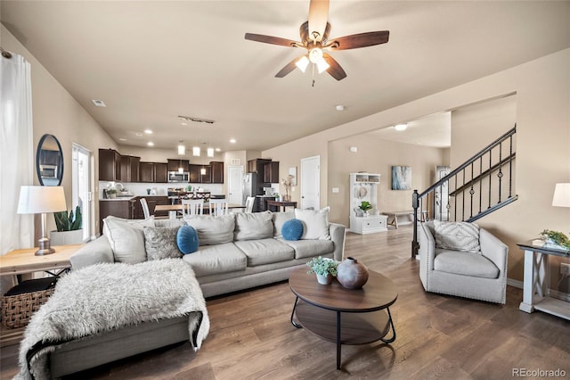 living area featuring stairway, baseboards, ceiling fan, and dark wood-style flooring