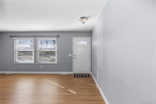 foyer entrance with hardwood / wood-style flooring and a textured ceiling