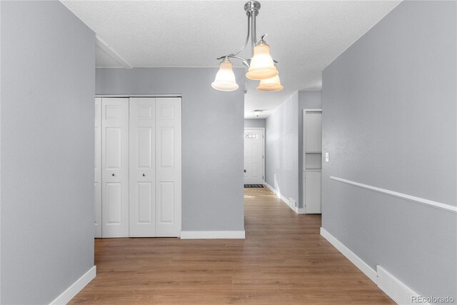 hall featuring wood-type flooring and a textured ceiling