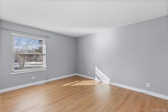 spare room featuring wood-type flooring and a textured ceiling