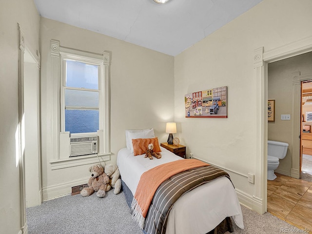 bedroom with cooling unit, baseboards, visible vents, carpet floors, and connected bathroom