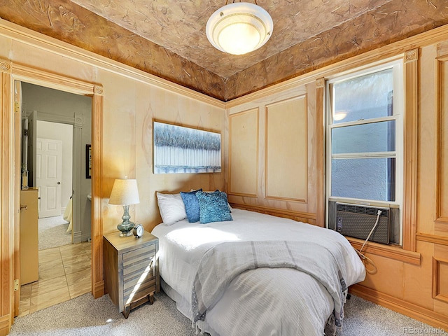 bedroom featuring light carpet, a decorative wall, and cooling unit