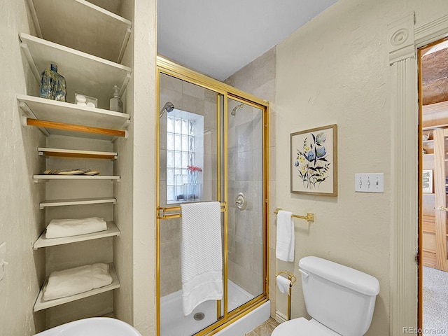 bathroom featuring a shower stall, toilet, and a textured wall