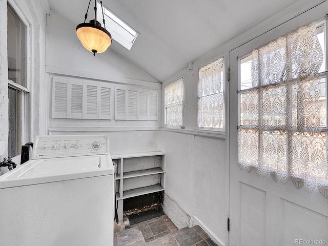 laundry area featuring stone finish flooring, washer / clothes dryer, a skylight, and laundry area