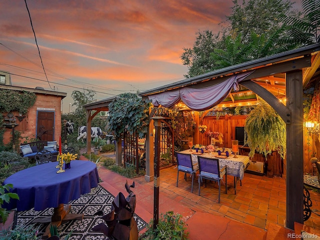 view of patio / terrace with an outbuilding, fence, outdoor dining area, a gazebo, and an outdoor hangout area