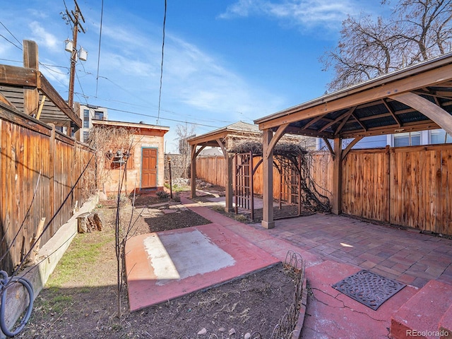 view of patio / terrace with a gazebo, a shed, an outdoor structure, and a fenced backyard