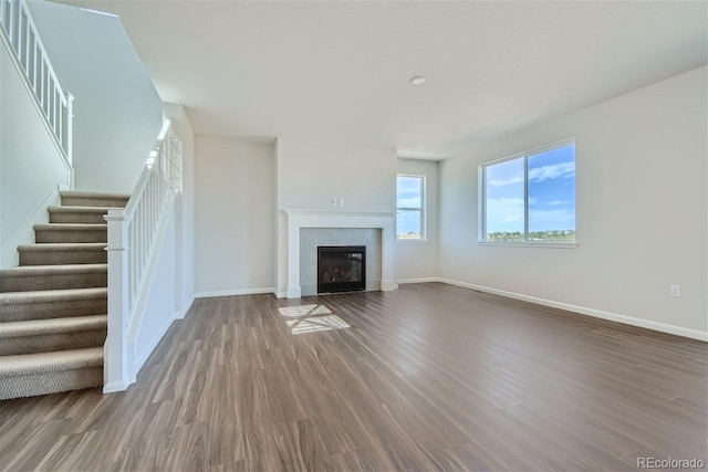 unfurnished living room with a tile fireplace and hardwood / wood-style flooring