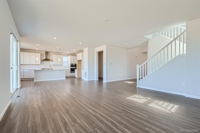 unfurnished living room featuring sink and dark hardwood / wood-style floors