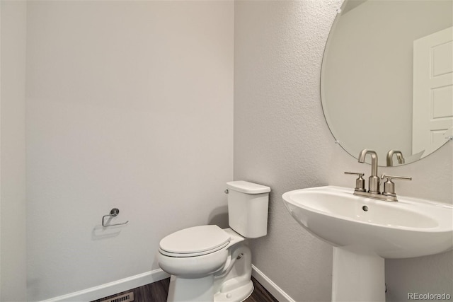 bathroom with hardwood / wood-style flooring, sink, and toilet