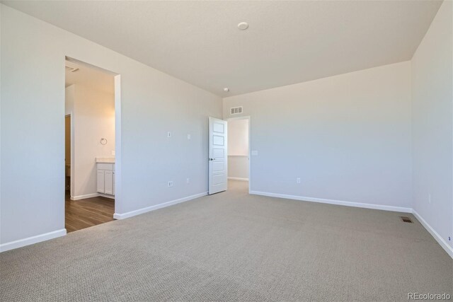 unfurnished bedroom with carpet flooring and ensuite bathroom