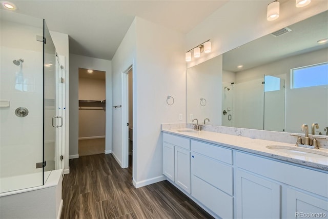 bathroom featuring hardwood / wood-style floors, vanity, and a shower with shower door