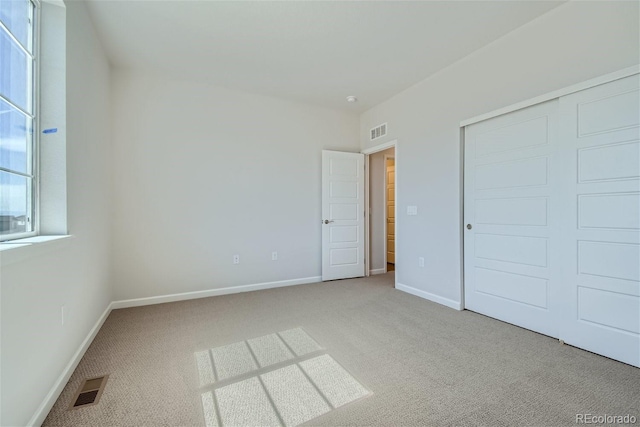 unfurnished bedroom with carpet flooring and a closet