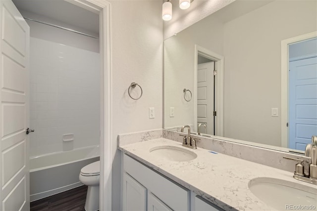 full bathroom featuring hardwood / wood-style floors, vanity, toilet, and bathtub / shower combination