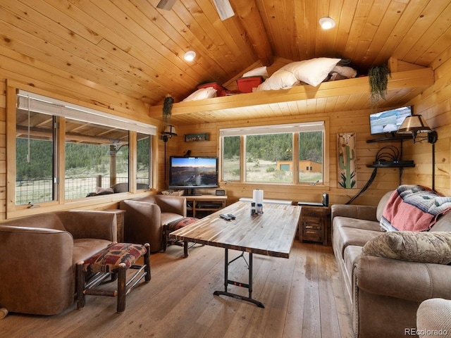 living room with hardwood / wood-style floors, lofted ceiling with beams, wooden ceiling, and wood walls