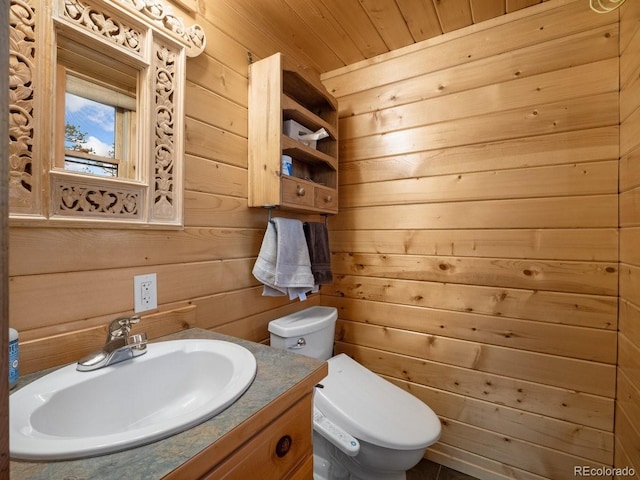 bathroom with vanity, wood walls, toilet, and wooden ceiling