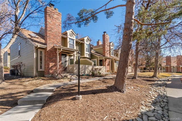 view of front of home featuring a chimney and central AC unit