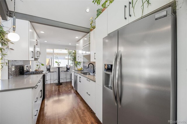 1380 S Dahlia St, Denver, CO 80222 - kitchen with white cabinets, appliances with stainless steel finishes, dark wood-style floors, and a sink