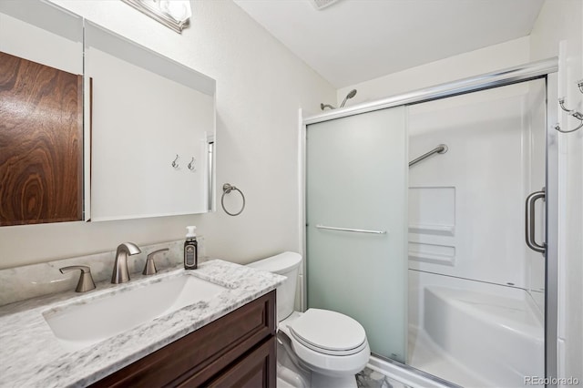 full bathroom with toilet, a stall shower, and vanity